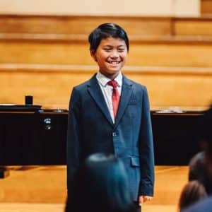 Student singing on stage - perform with Vivaldi Music Academy